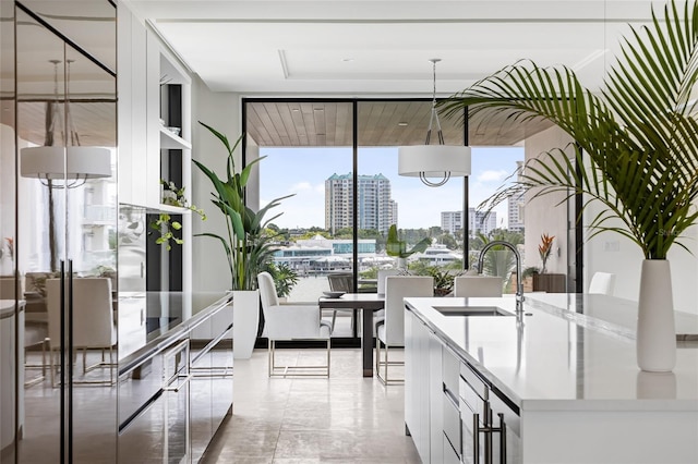 509 Golden Gate Pt Unit 3, Sarasota, FL 34236 - kitchen with a sink, a wall of windows, light countertops, white cabinetry, and open shelves