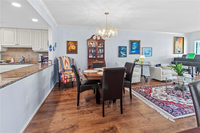 dining room featuring crown molding, dark wood-type flooring, and a chandelier