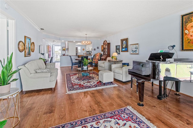 living room with crown molding, hardwood / wood-style floors, and a chandelier