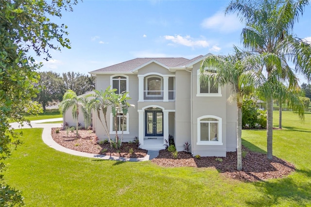 view of front facade featuring french doors, a balcony, and a front yard