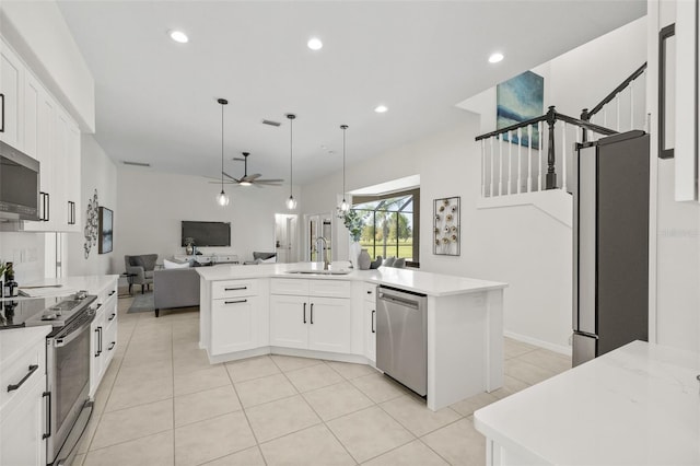 kitchen with white cabinetry, ceiling fan, a center island, sink, and appliances with stainless steel finishes