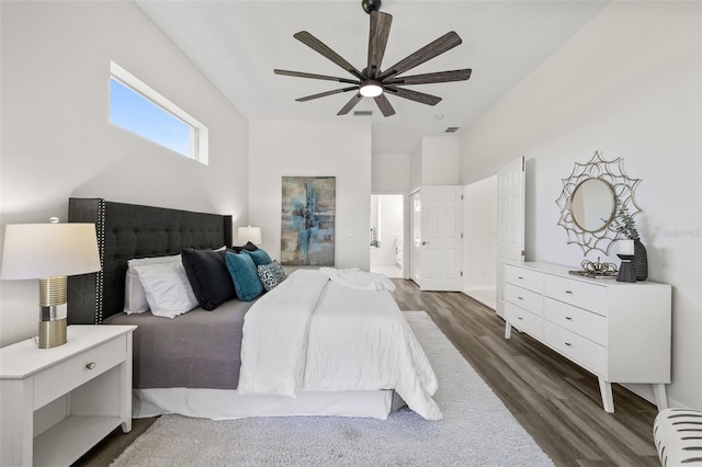 bedroom with ceiling fan, ensuite bathroom, and dark wood-type flooring