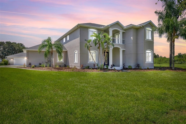 view of front of property with a balcony and a yard