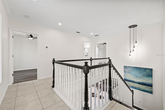 hallway with light tile patterned flooring and ornamental molding