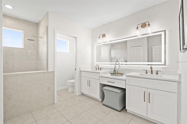 bathroom featuring tile patterned floors, vanity, toilet, and a healthy amount of sunlight