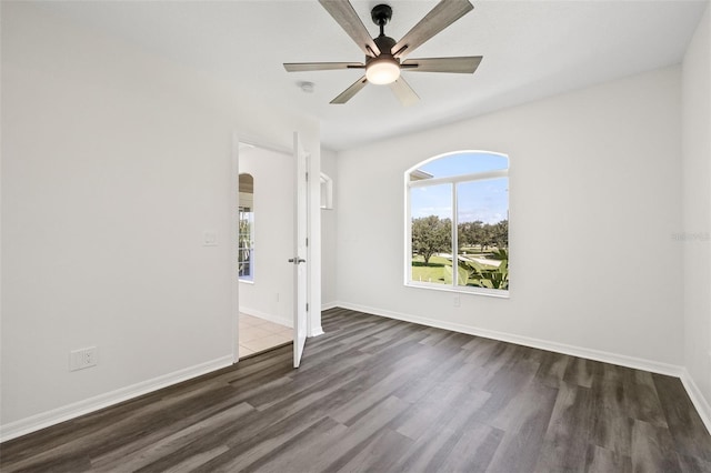 unfurnished room with ceiling fan and dark wood-type flooring