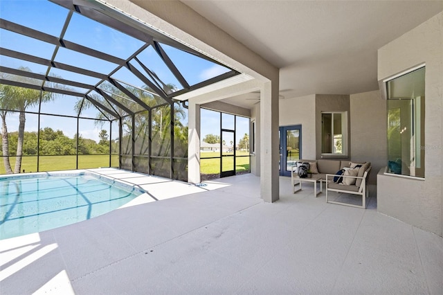 view of pool with outdoor lounge area, a patio area, a yard, and glass enclosure