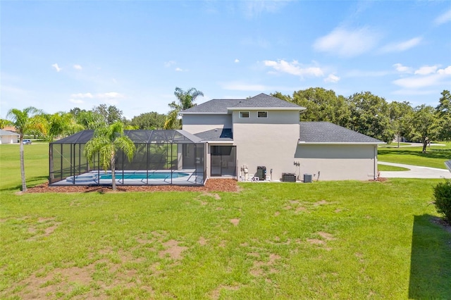 back of property with central air condition unit, a lanai, and a lawn