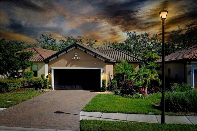 mediterranean / spanish home featuring a yard and a garage