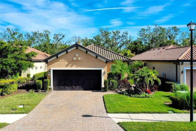 mediterranean / spanish-style house featuring a front lawn and a garage