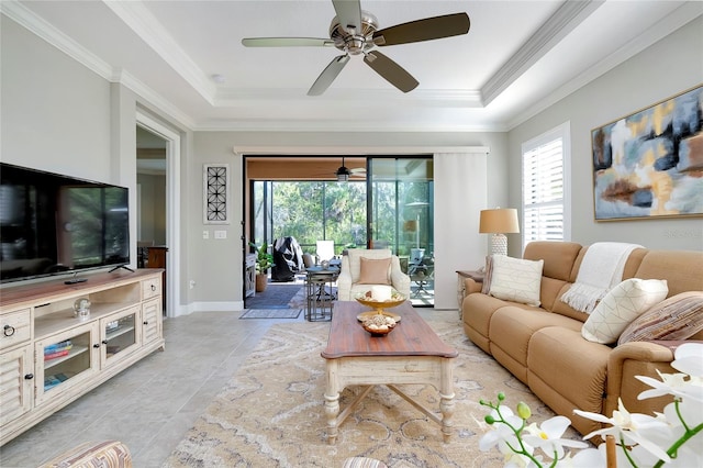 living room featuring light tile patterned floors, crown molding, and a tray ceiling