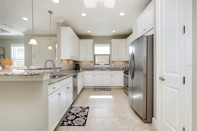 kitchen featuring backsplash, white cabinets, hanging light fixtures, light stone counters, and stainless steel appliances