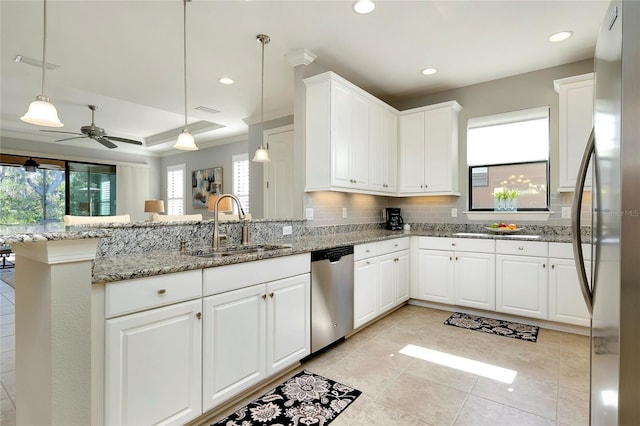 kitchen featuring pendant lighting, kitchen peninsula, decorative backsplash, appliances with stainless steel finishes, and white cabinetry