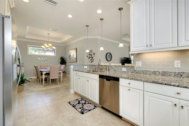 kitchen featuring appliances with stainless steel finishes, decorative light fixtures, light stone counters, and sink