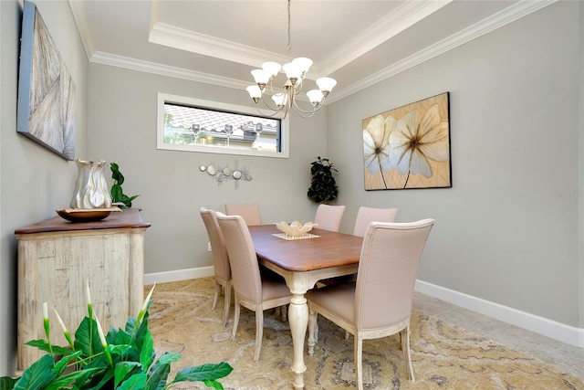 dining room featuring a tray ceiling, an inviting chandelier, and crown molding