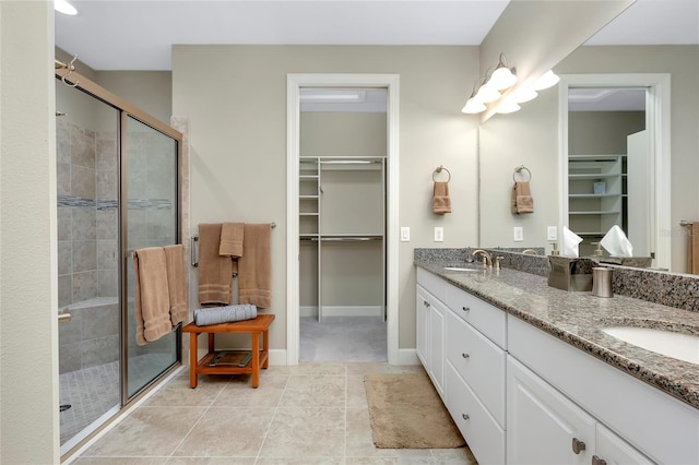 bathroom with tile patterned flooring, vanity, and walk in shower