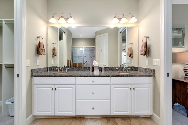 bathroom with vanity and a shower with door