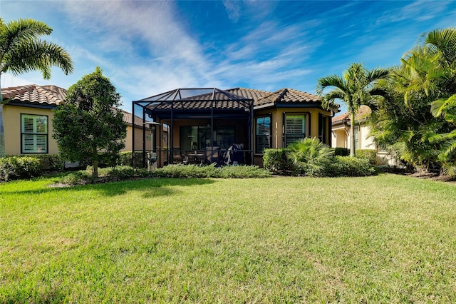 back of property featuring a lawn and a lanai