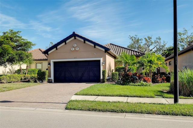 mediterranean / spanish house featuring a front yard and a garage