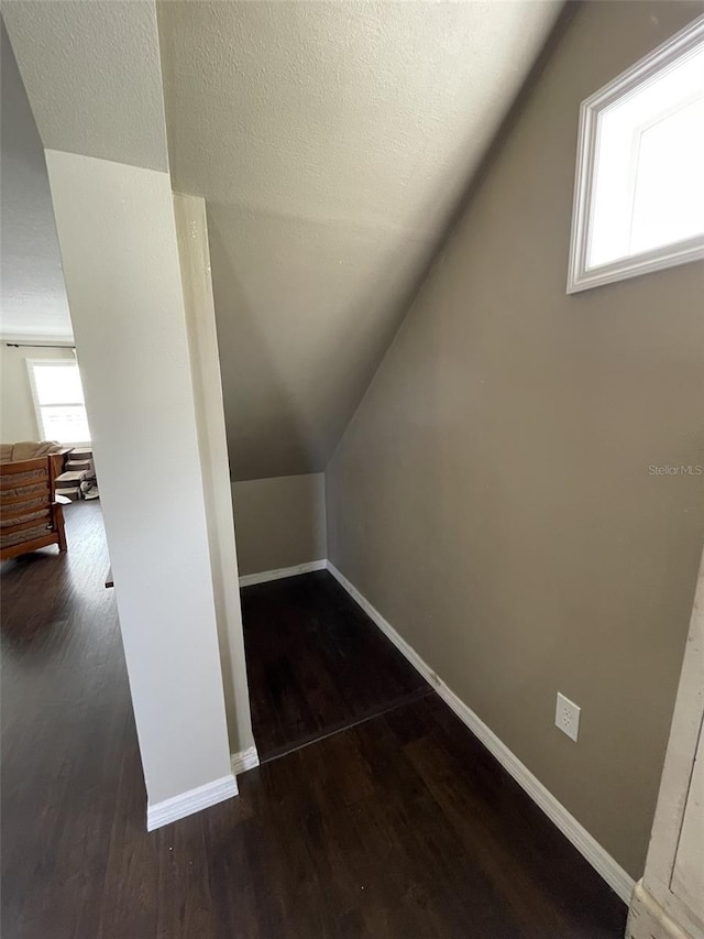 bonus room with dark hardwood / wood-style flooring and lofted ceiling