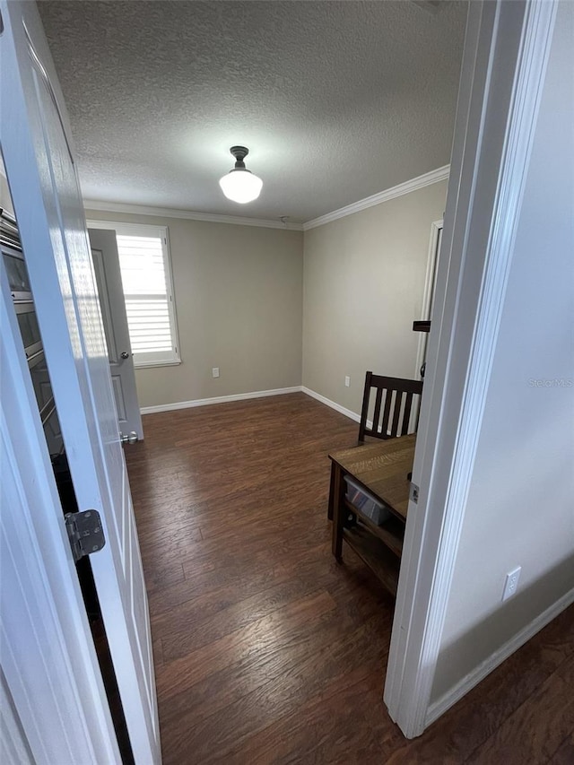 interior space with a textured ceiling, dark hardwood / wood-style floors, and ornamental molding