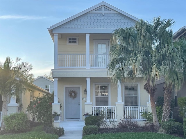 view of front of property featuring a balcony, a porch, and stucco siding