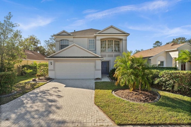 view of property featuring a garage and a front lawn