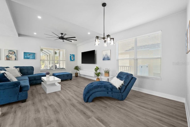 living room with wood-type flooring and ceiling fan with notable chandelier