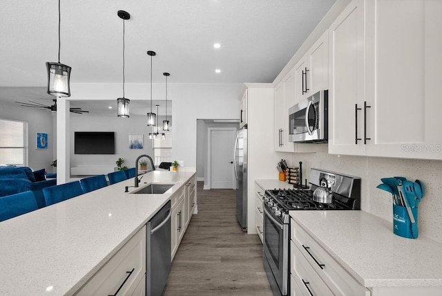 kitchen featuring sink, white cabinets, stainless steel appliances, and light hardwood / wood-style flooring