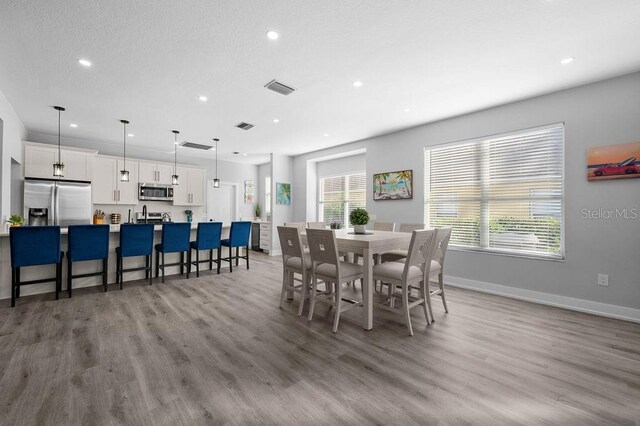 dining area featuring hardwood / wood-style flooring and a healthy amount of sunlight