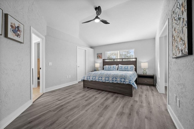 bedroom featuring ceiling fan, light hardwood / wood-style flooring, and vaulted ceiling