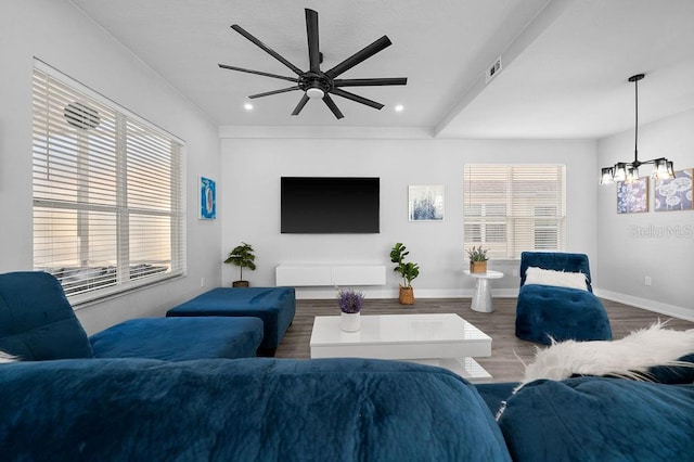 living room featuring hardwood / wood-style floors and ceiling fan with notable chandelier