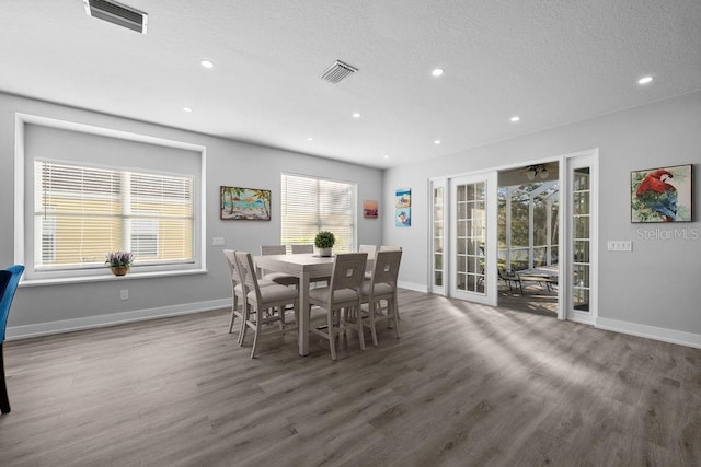 dining space with dark hardwood / wood-style floors, a textured ceiling, and french doors