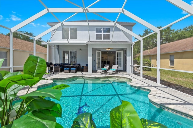 view of pool featuring an outdoor living space, a patio, and a lanai