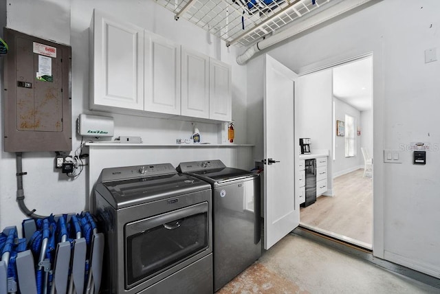 washroom with electric panel, cabinets, and independent washer and dryer