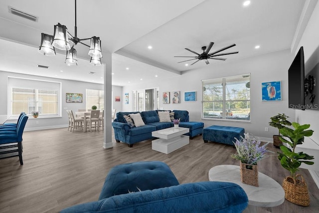 living room featuring wood-type flooring and ceiling fan with notable chandelier