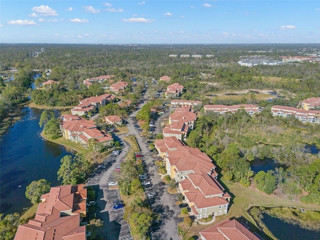 drone / aerial view with a residential view, a water view, and a view of trees