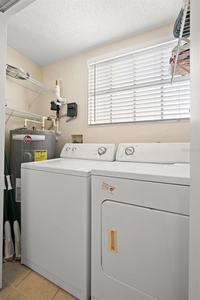 washroom featuring light tile patterned floors, a textured ceiling, independent washer and dryer, and plenty of natural light