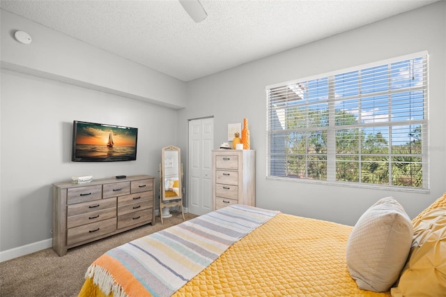 carpeted bedroom with multiple windows, ceiling fan, a textured ceiling, and baseboards