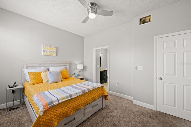 carpeted bedroom featuring ceiling fan, baseboards, a textured ceiling, and ensuite bathroom