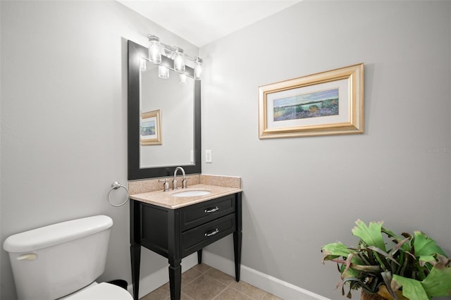 bathroom with toilet, tile patterned flooring, baseboards, and vanity