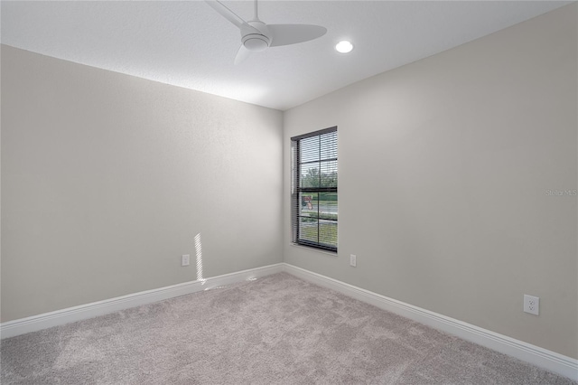 empty room featuring ceiling fan and light colored carpet