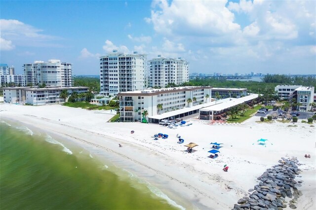 birds eye view of property with a water view and a beach view