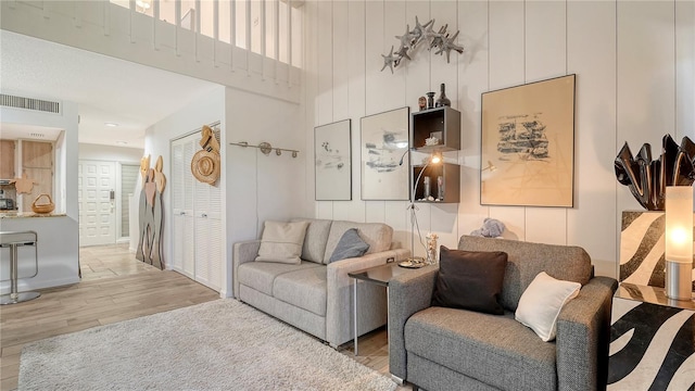 living room featuring a towering ceiling and hardwood / wood-style flooring