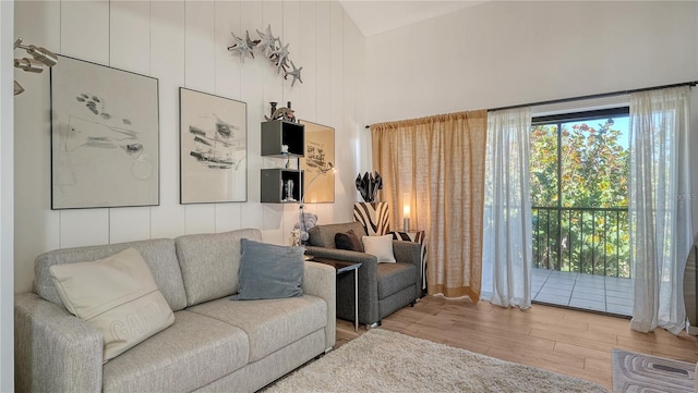 living room featuring high vaulted ceiling and light hardwood / wood-style flooring