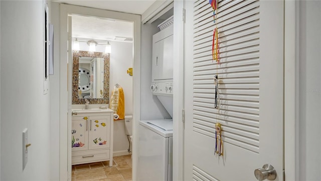 clothes washing area with sink and stacked washer and clothes dryer