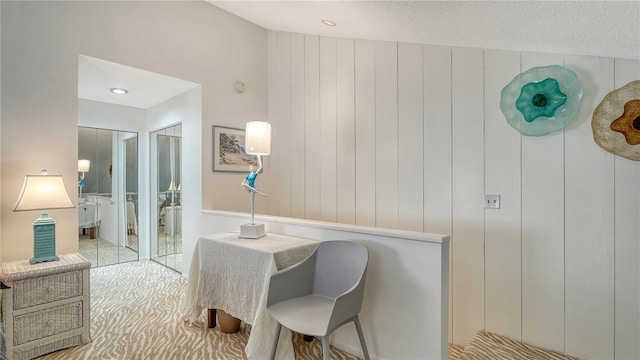 interior space with wood walls, light colored carpet, and a textured ceiling