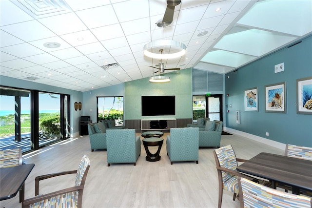 living room with light wood-type flooring, a wealth of natural light, and vaulted ceiling