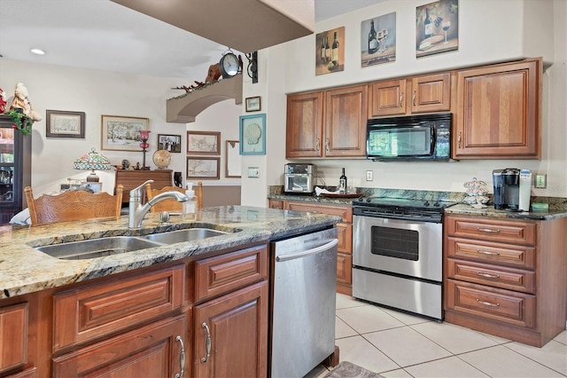 kitchen featuring appliances with stainless steel finishes, light stone counters, light tile patterned floors, and sink