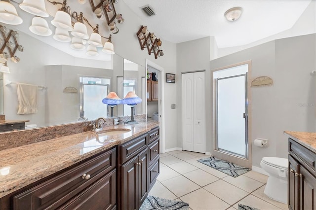 bathroom featuring tile patterned floors, vanity, a textured ceiling, a shower, and toilet